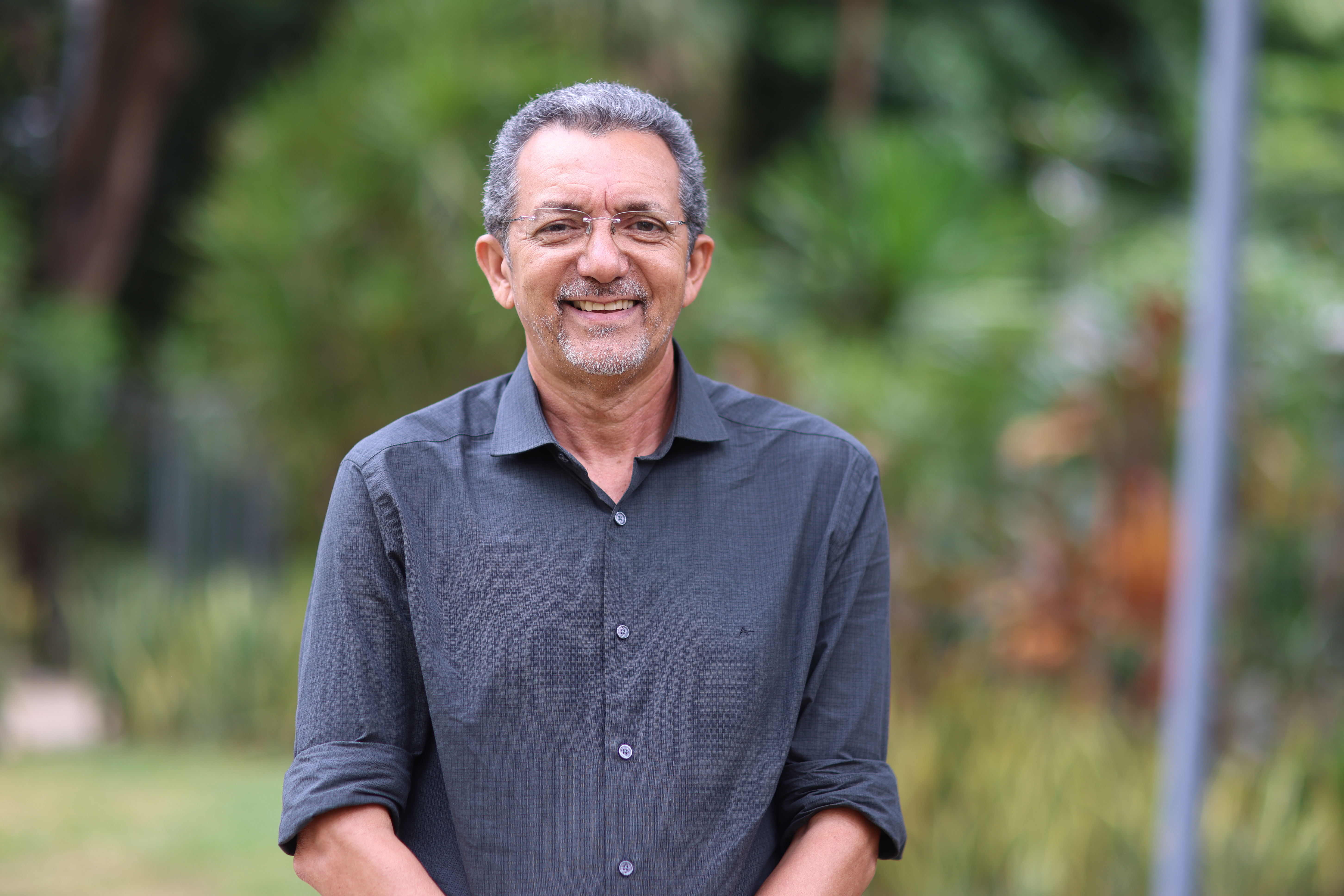 Julio Costa posa para a foto de camisa azul, ele é um homem branco de cabelo grisalho